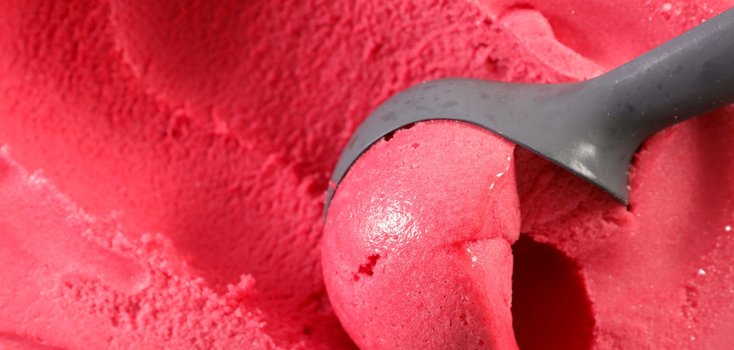 A scoop of red-colored ice cream